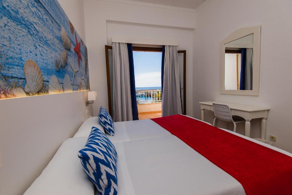 卡拉纳雅达卡拉拉提雅达旅馆的配有一张床、一张书桌和一扇窗户的酒店客房