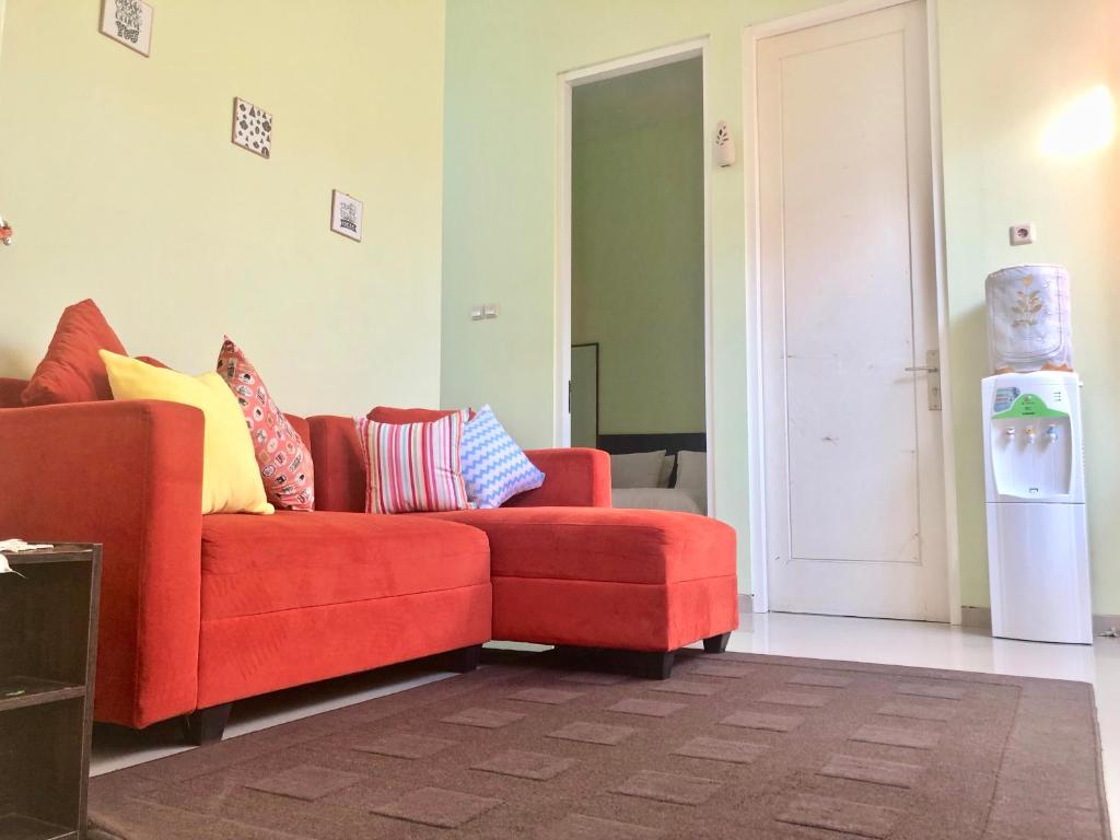 巴图Villa Safira的客厅配有红色沙发及色彩缤纷的枕头