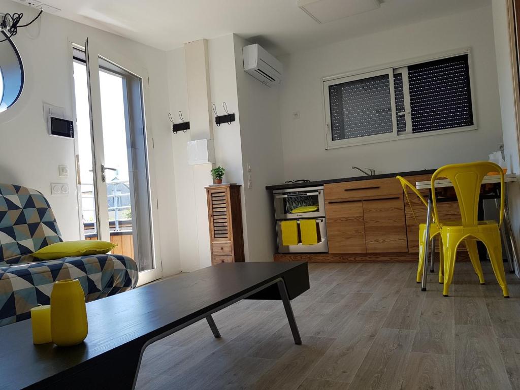 昂热Angers Green Lodge - Yellow Sun Appartement的客厅配有桌子和黄色椅子