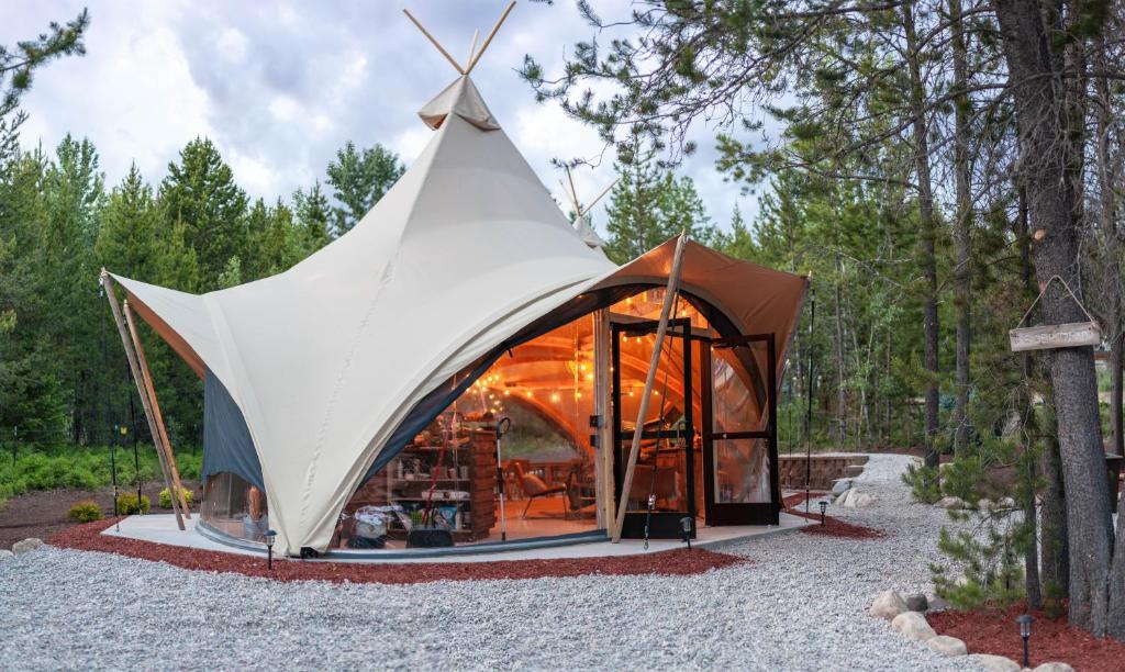 Coram坎瓦斯冰川下旅馆的树林中带白色大屋顶的帐篷