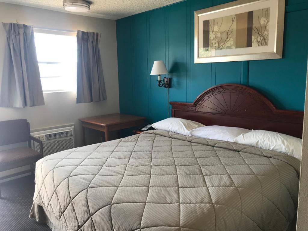 EufaulaLakeside inn的一间卧室设有一张大床和蓝色的墙壁