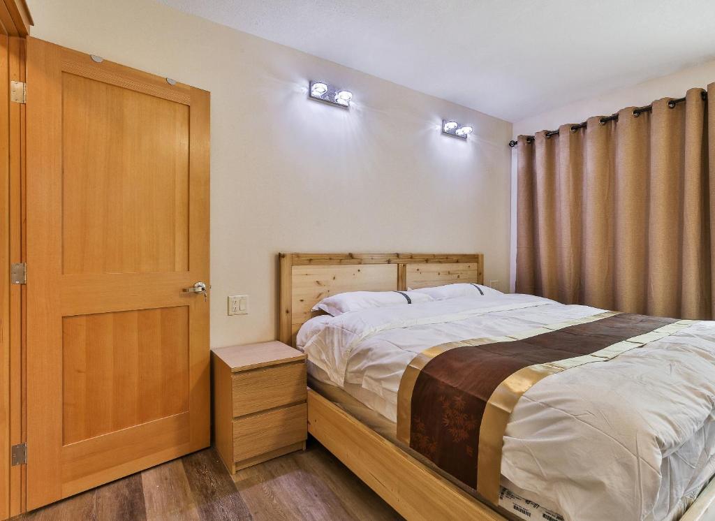 班夫Riverfront Estate Bed&Breakfast Banff的一间卧室配有一张床和一扇木门