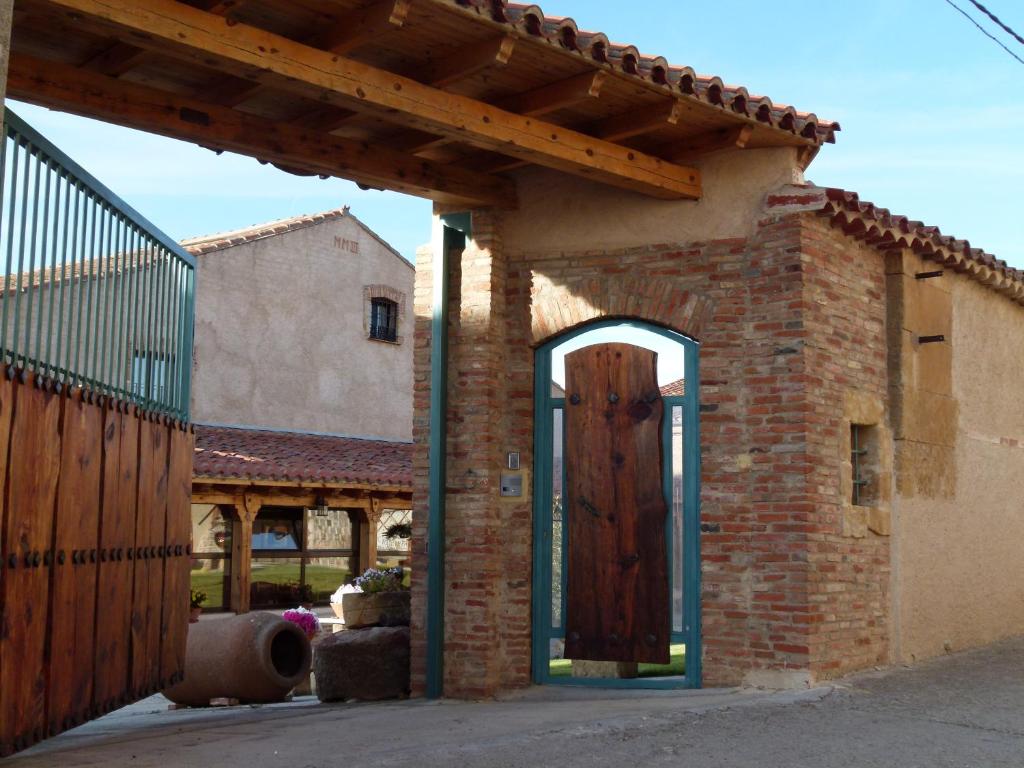 El PerdigónHotel Rural El Perdigón的砖砌的建筑,设有木门和栅栏