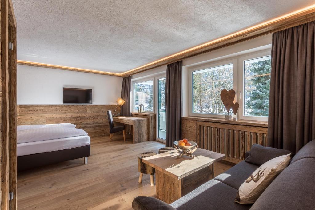 蒂罗尔-基希贝格Almhof Kitzlodge - Alpine Lifestyle Hotel的酒店客房,配有床和沙发