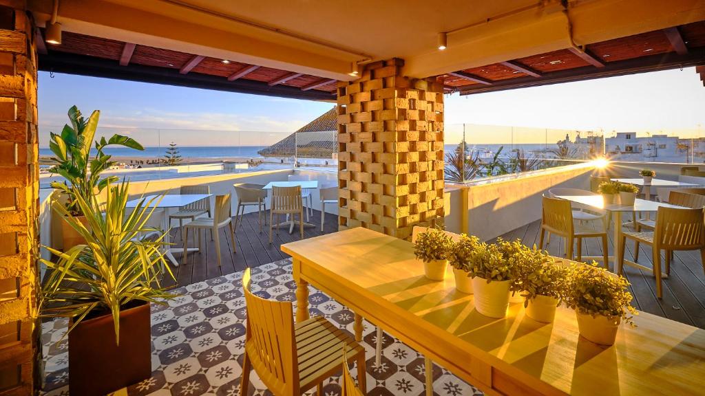 科尼尔-德拉弗龙特拉Hostal Campito的一个带桌椅的海景庭院