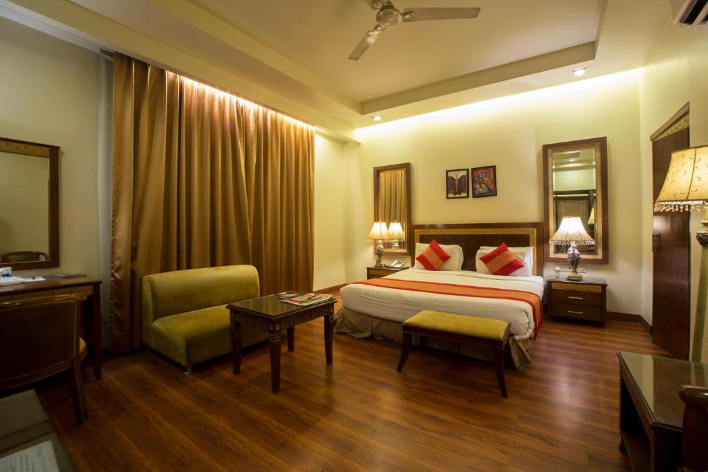 新德里Hotel Picasso Paschim Vihar Delhi - Couple Friendly Local IDs Accepted的酒店客房配有一张床铺和一张桌子。