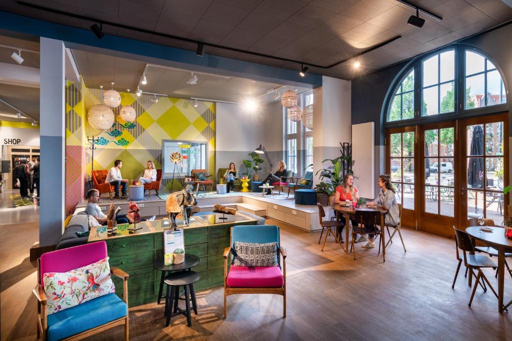 阿姆斯特丹Stayokay Hostel Amsterdam Oost的餐馆,餐厅里有人坐在餐桌旁