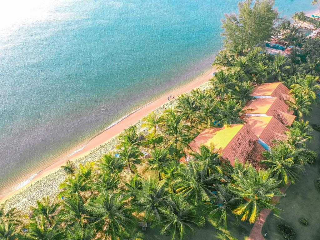 富国法米亚纳Spa度假酒店的享有棕榈树海滩和大楼的顶部景色