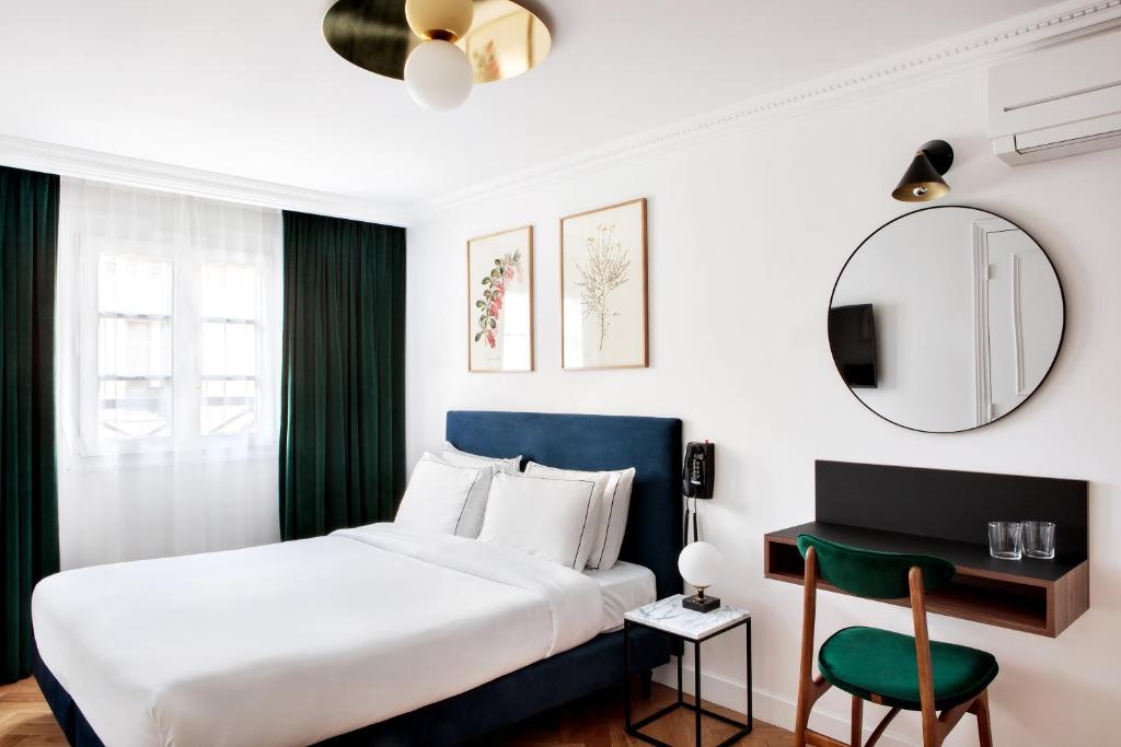 巴黎巴蒂尼奧勒浪漫约会酒店的一间卧室配有一张床、一张桌子和一面镜子