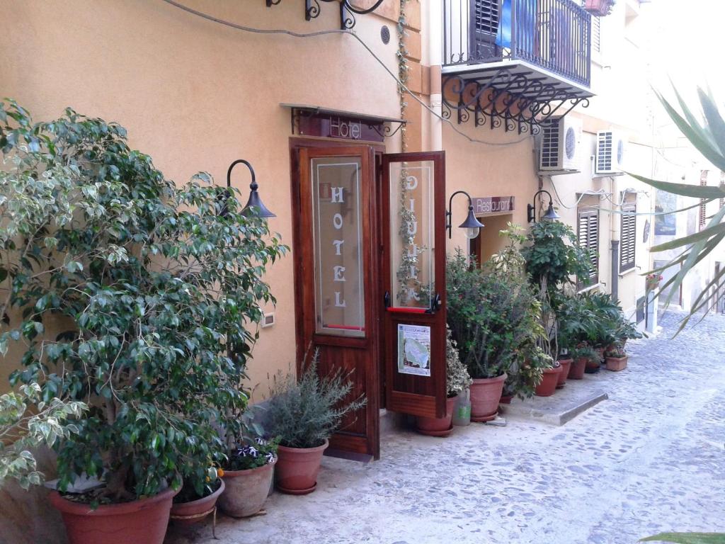 乌斯蒂卡Hotel Giulia的楼前一排盆栽植物