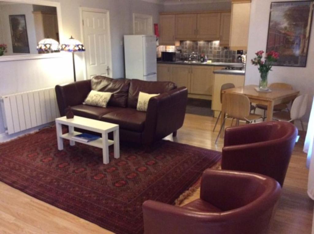 斯丹斯达蒙费雪特Stansted spacious 2-bed apartment, easy access to Stansted Airport & London的客厅配有沙发、椅子和桌子
