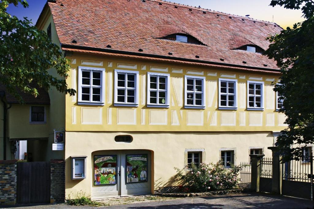 拉德博伊尔Weingut Haus Steinbach的黄色的房屋,有红色的屋顶