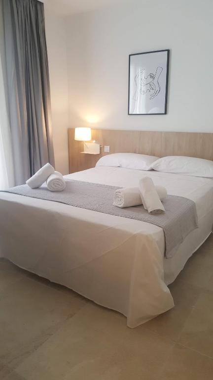 埃斯卡斯特利Hotel Victori的一张白色的大床,带两条毛巾