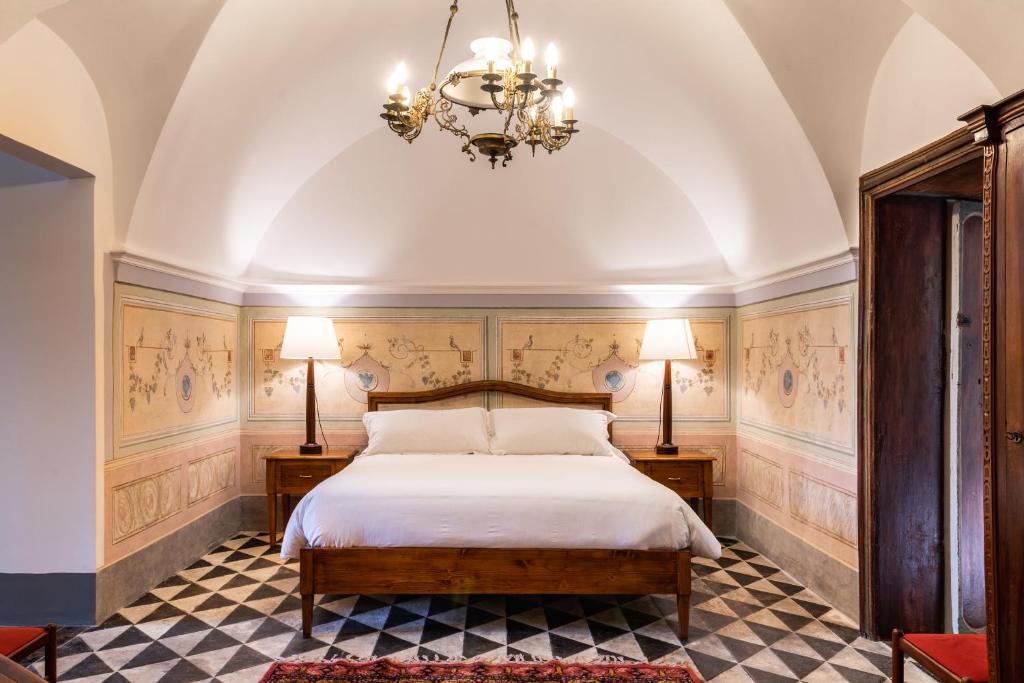 拉古萨Baroni Giampiccolo Suite的一间卧室配有一张床和一个吊灯