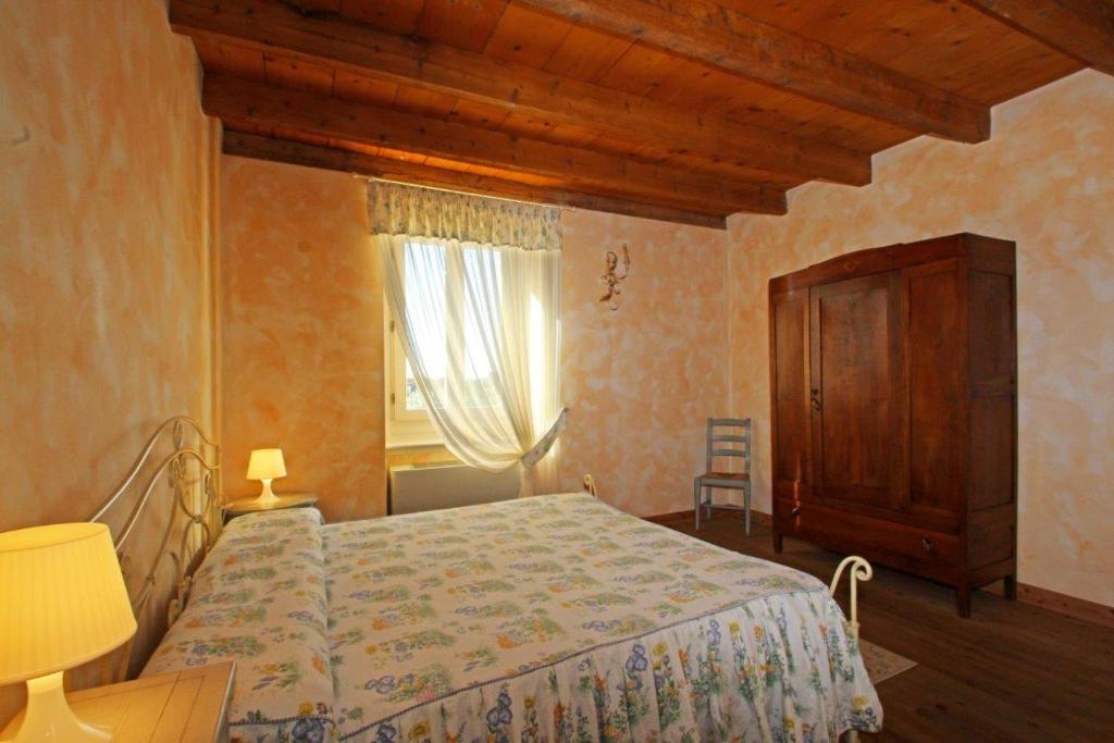 代森扎诺-德尔加达普雷塞列农舍乡村民宿的一间卧室配有一张床、一个梳妆台和一扇窗户。