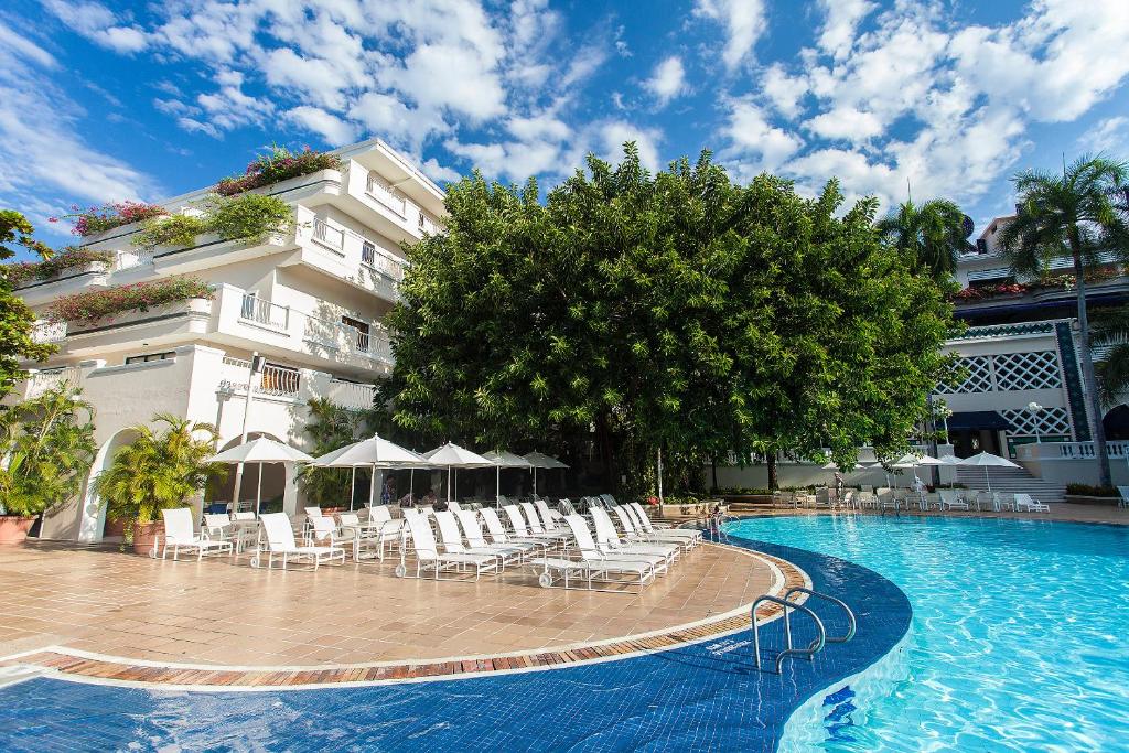 吉拉尔多特托卡勒玛酒店的一座带椅子的游泳池以及一座建筑