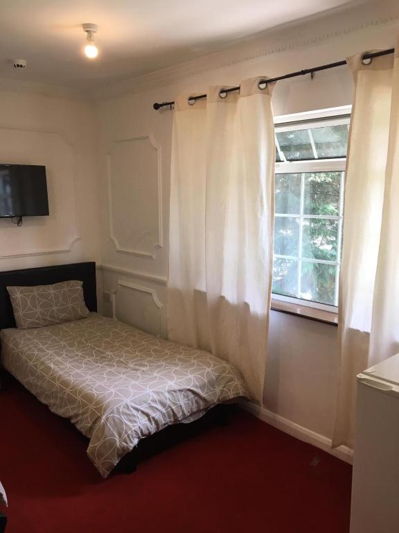 哈特菲尔德Hatfield SAVE-MONEY Rooms - 10over10 for PRICE!的一间卧室配有床和带窗帘的窗户