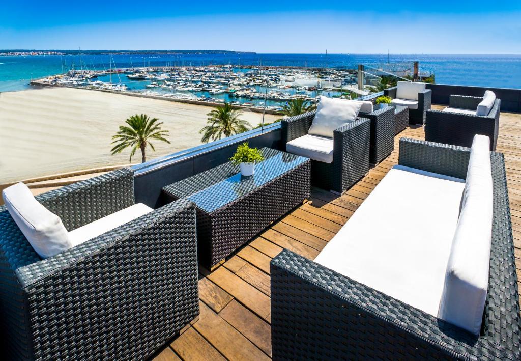 坎帕斯蒂利亚诺蒂卡酒店的阳台配有藤椅,享有海滩美景