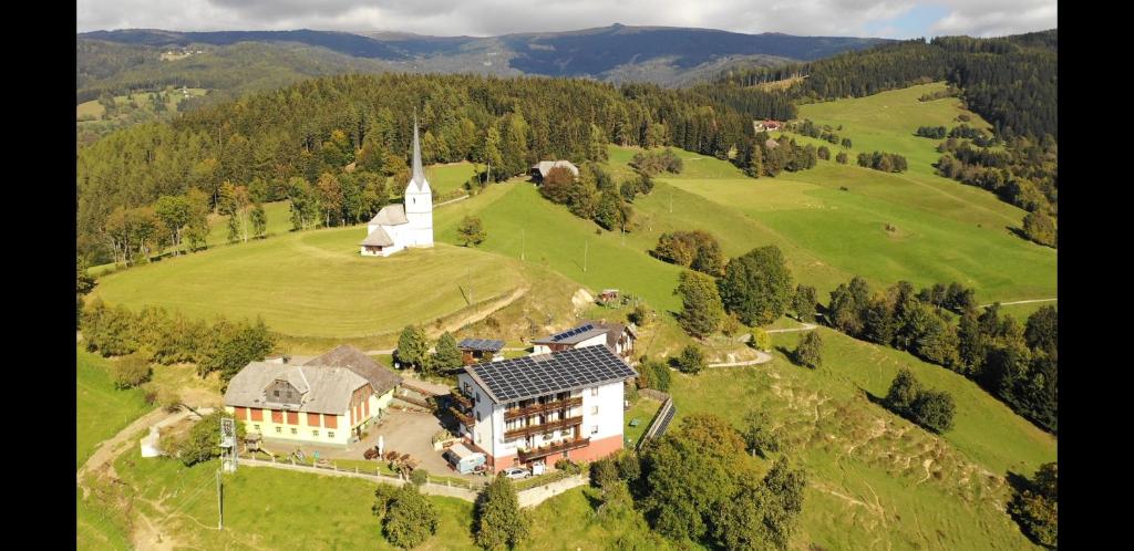 Eberstein加斯特霍夫古特曼酒店的享有山上房屋的空中景致,设有教堂