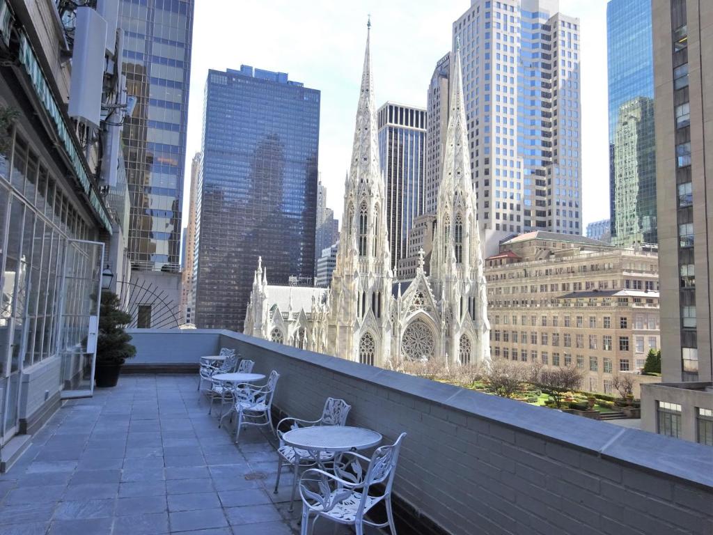 纽约西部三号俱乐部酒店的一个带桌椅的阳台和一个大教堂