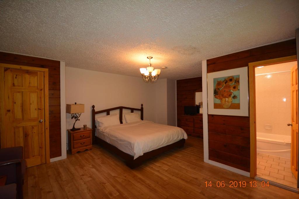 圣阿黛拉奥伯格高山酒店的一间卧室配有一张床,浴室设有浴缸