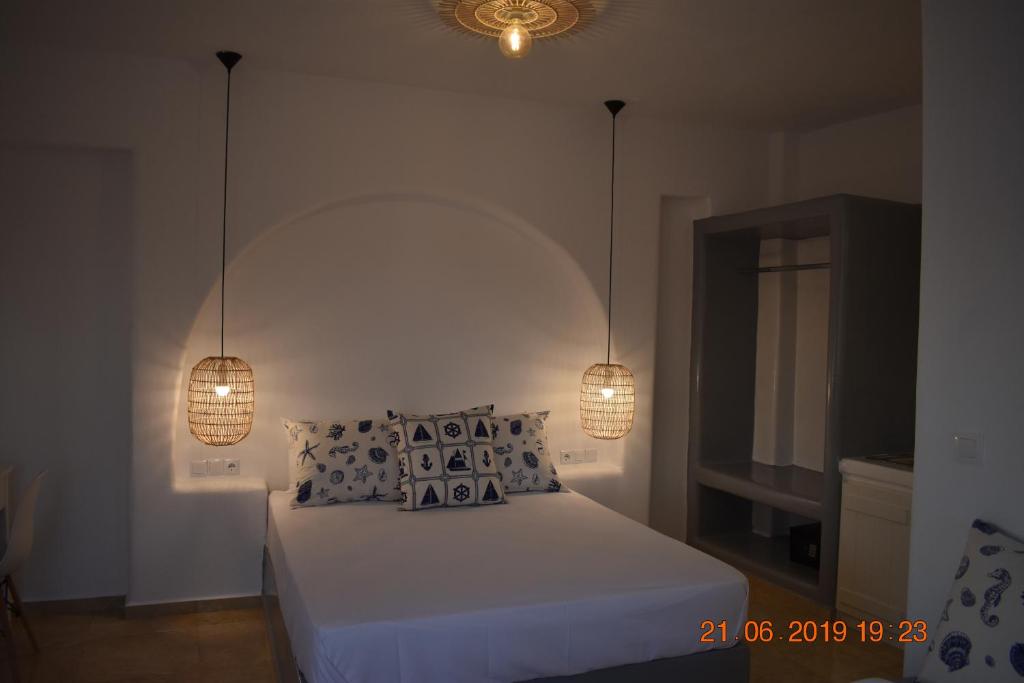 纳克索乔拉Infinity Apartments的一间卧室配有一张带两个灯的床
