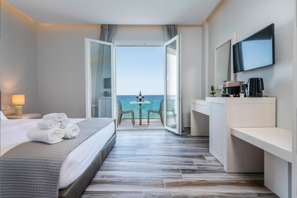 卡尔扎迈纳Kyma Rooms & Suites的酒店客房设有一张床,享有海景。