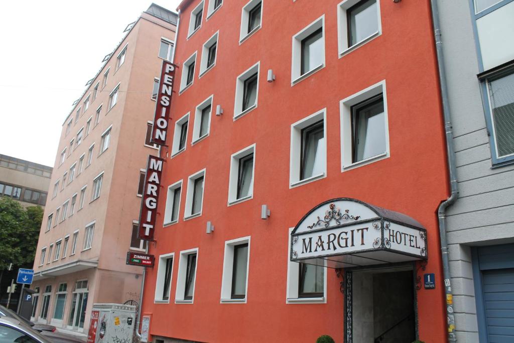 慕尼黑Hotel Margit的一座红色的建筑,上面有马里奥特酒店标志