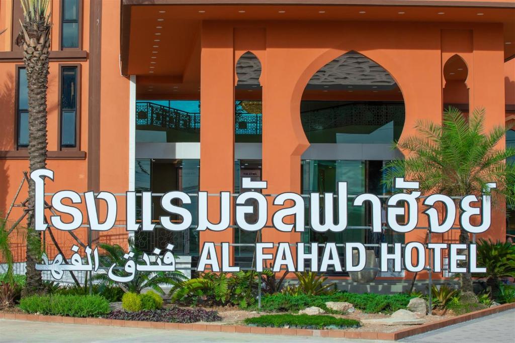 合艾Alfahad Hotel的大楼前的酒店标志
