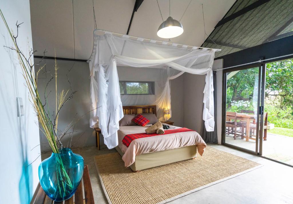 卡蒂马穆利洛Caprivi Mutoya Lodge and Campsite的一间卧室配有一张带天蓬的床