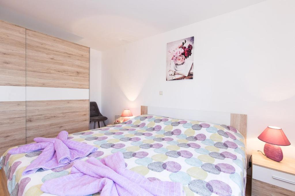 瓦比尼科Apartment Adrijana的一间卧室配有一张床铺,床上铺有紫色毯子