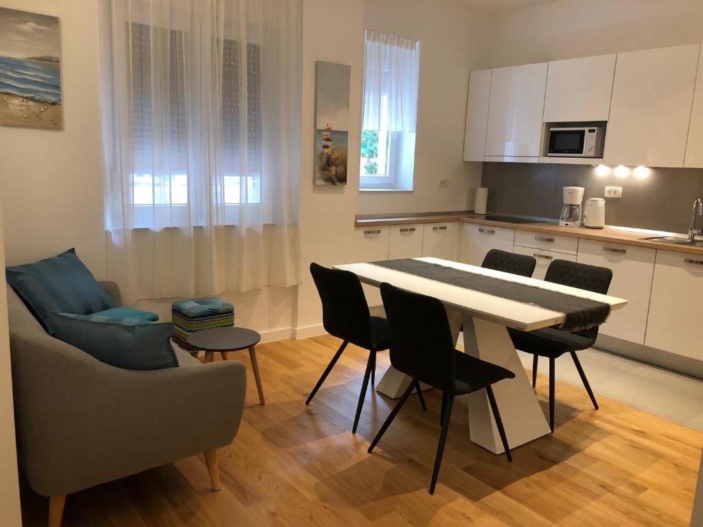斯普利特Tempus Apartment的厨房以及带桌椅的起居室。