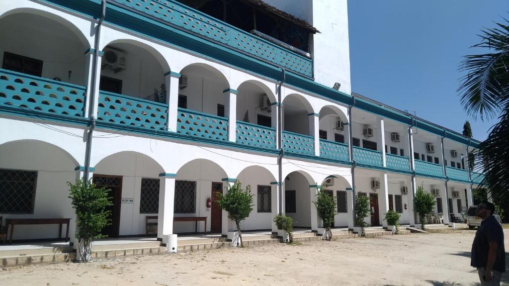 达累斯萨拉姆Cefa Hostel的白色的大建筑,设有蓝色的阳台