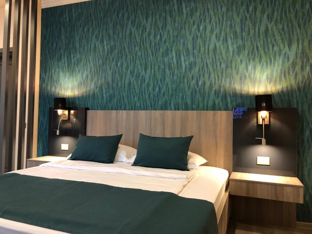 皮亚特拉-尼亚姆茨Pensiunea Lido的一间卧室配有一张带绿色墙壁的床