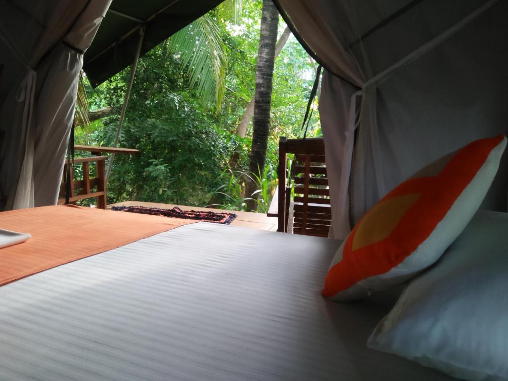 达瓦拉维Makulu Safari Camping的森林景帐篷内的一张床位