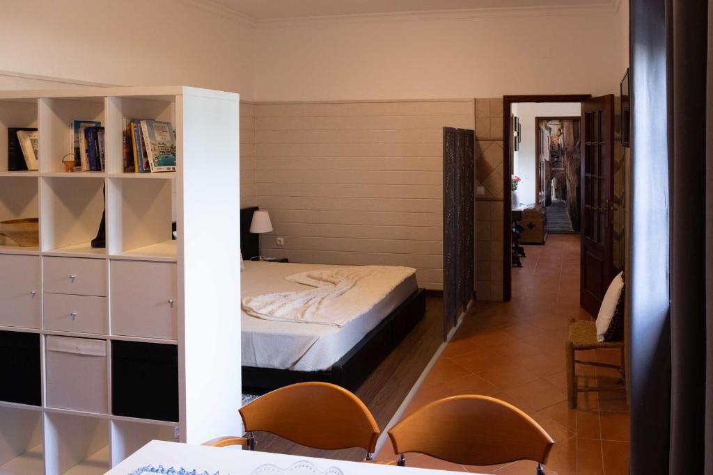 莫托拉AL Ribeirinho的一间卧室设有一张床和一个书架