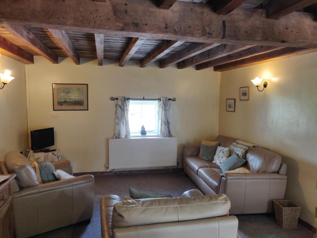 米勒姆Row Farm Cottage的客厅设有两张沙发和一个窗户