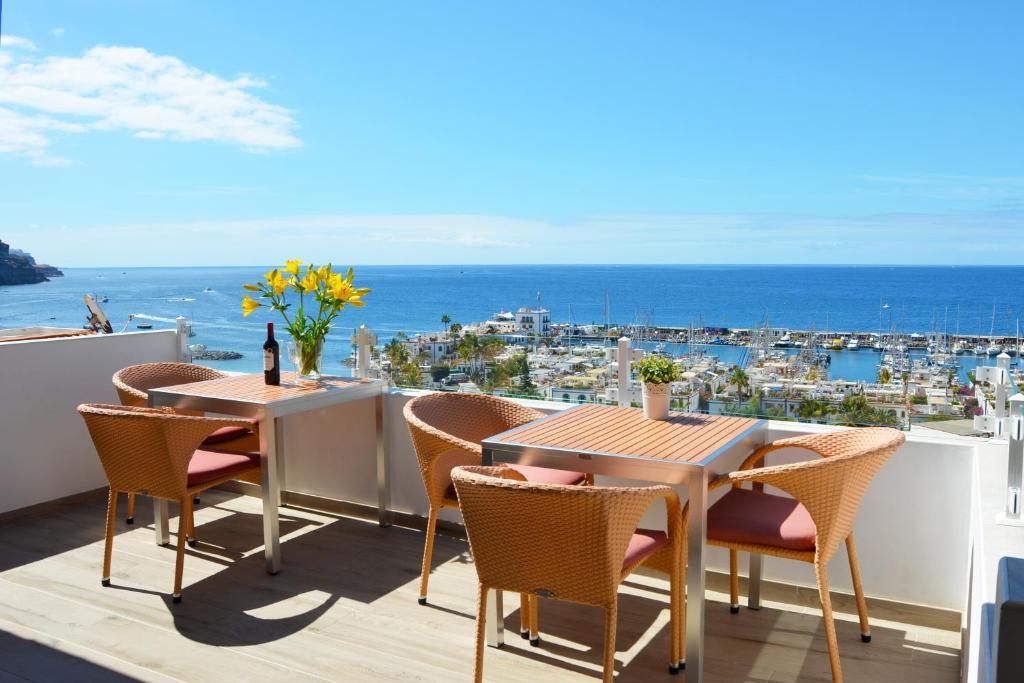 莫甘海滩Bella Vista Sun Club的阳台配有桌椅,享有海景。