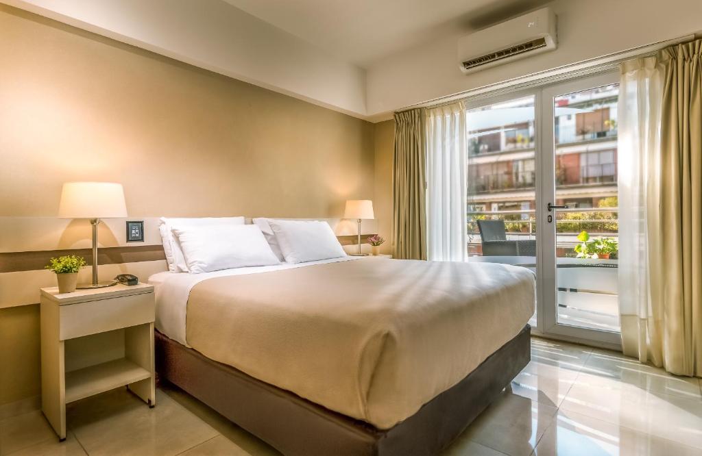 布宜诺斯艾利斯Up Recoleta Hotel的一间卧室设有一张大床和一个大窗户