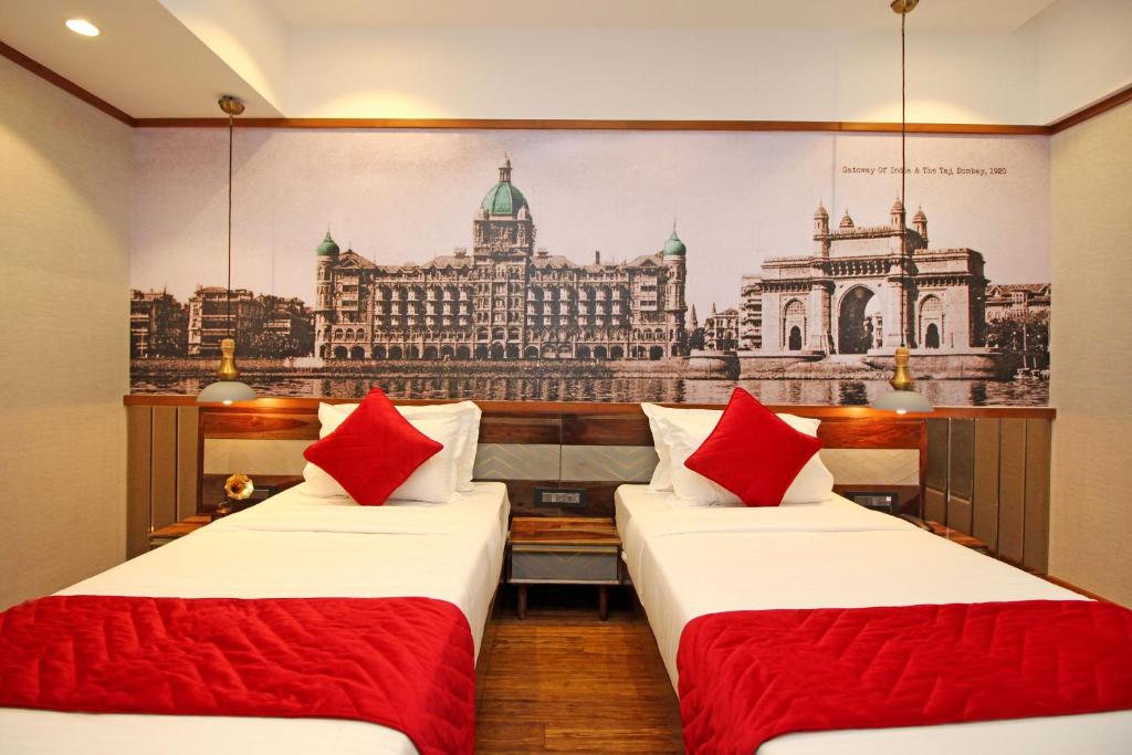 孟买Theory9 Premium Service Apartments Khar的一张位于一间客房的两张床,享有大楼的图片