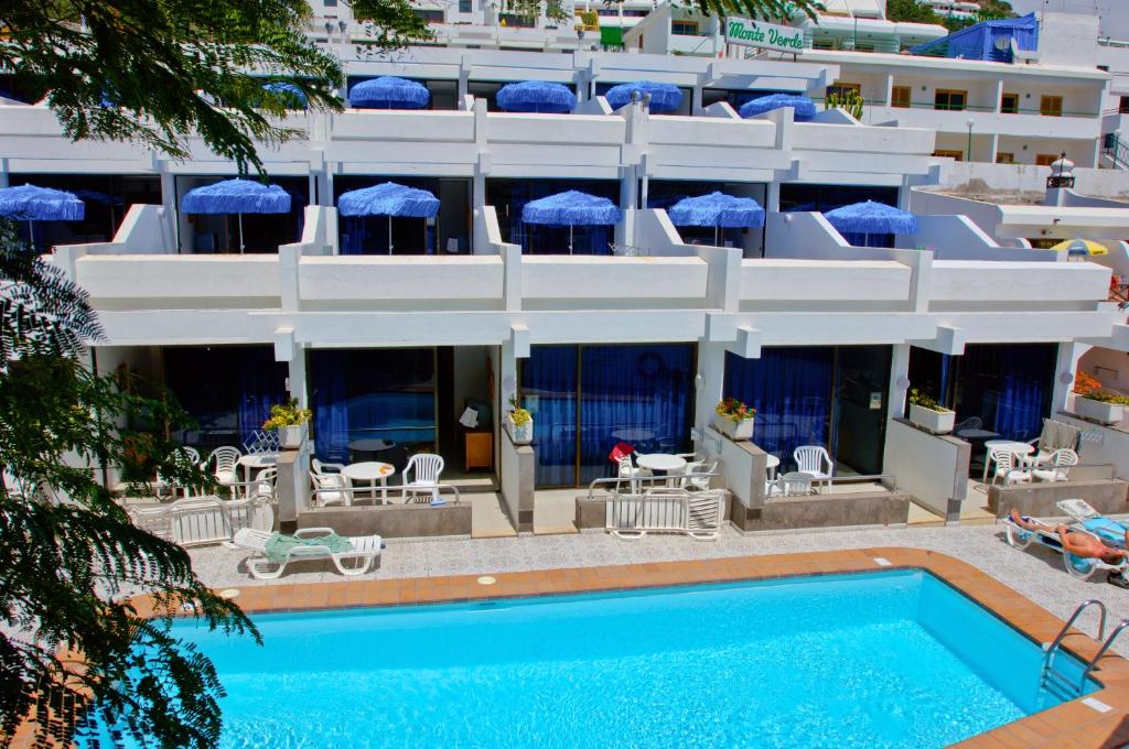 波多黎各Apartamentos Monte Verde的大楼前设有游泳池的酒店