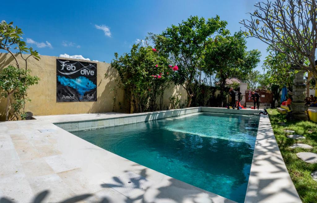 艾湄湾巴厘岛法布潜水中心旅舍的一座房子的院子内的游泳池