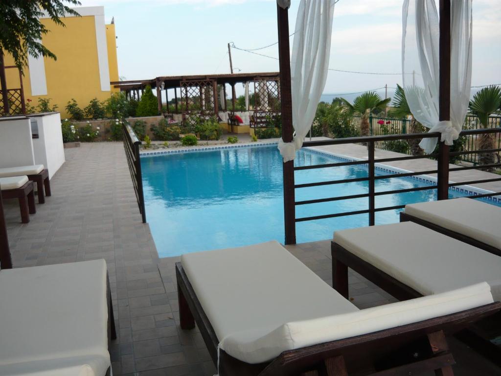 萨莫色雷斯Victory Apartments Hotel的一个带游泳池和一些椅子的度假胜地