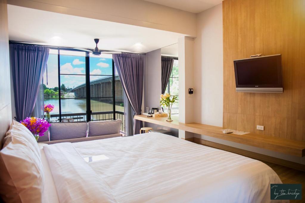 甘烹碧Home by the Bridge - SHA Certified的一间卧室设有一张床、一台电视和一个窗口。