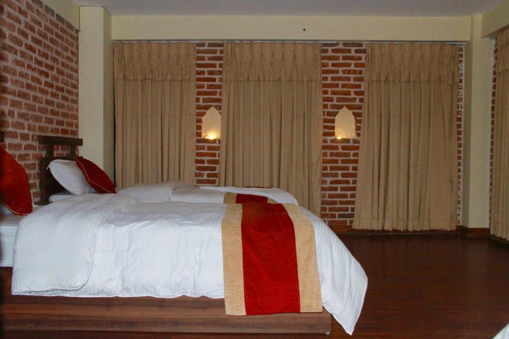 巴克塔普尔HOTEL LAYAKU DURBAR的一间卧室配有一张砖墙床