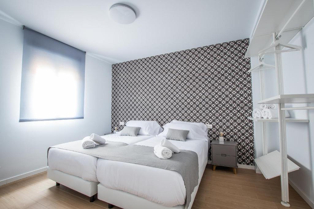 格拉纳达Ibericabeds Granada的白色的卧室设有白色的床和墙壁