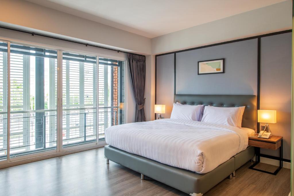 Ban Phraek SaMayson Place Hotel的一间卧室设有一张大床和大窗户