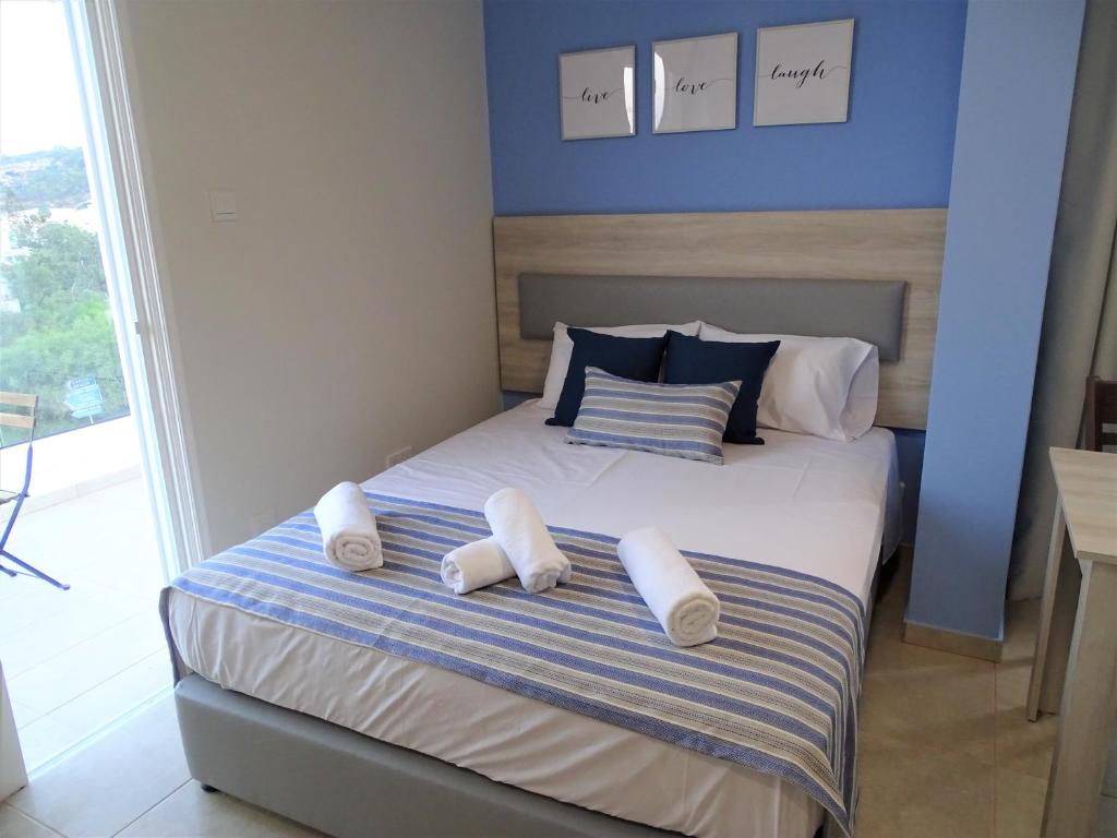 普罗塔拉斯Proteas Mare Suites的一间卧室配有一张带白色毛巾的床