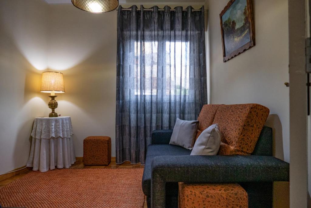 米兰德拉TUACASA的客厅设有蓝色的沙发和窗户。