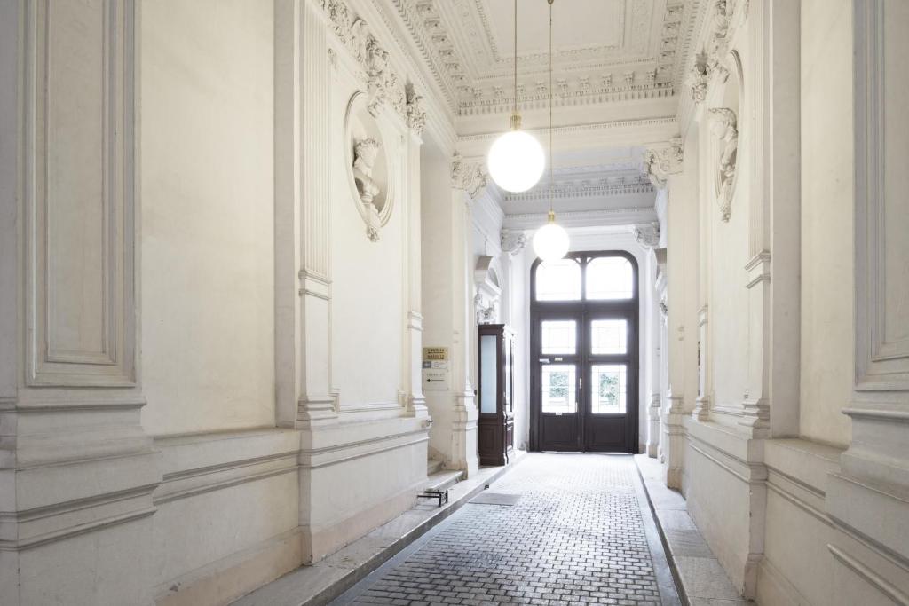 维也纳City-Maisonette的一条空的走廊,有门,铺着瓷砖地板